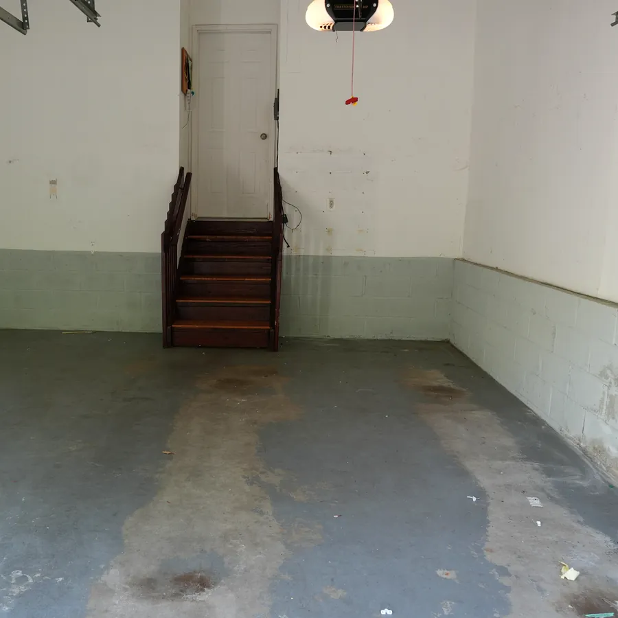 Before: stained bare concrete garage floor with oil marks